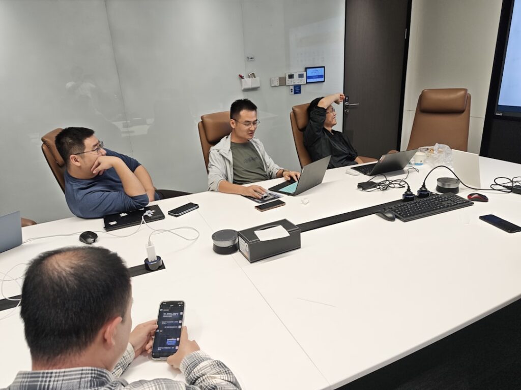 Professional business meeting with team members discussing around conference table with laptops for agency evaluation demo